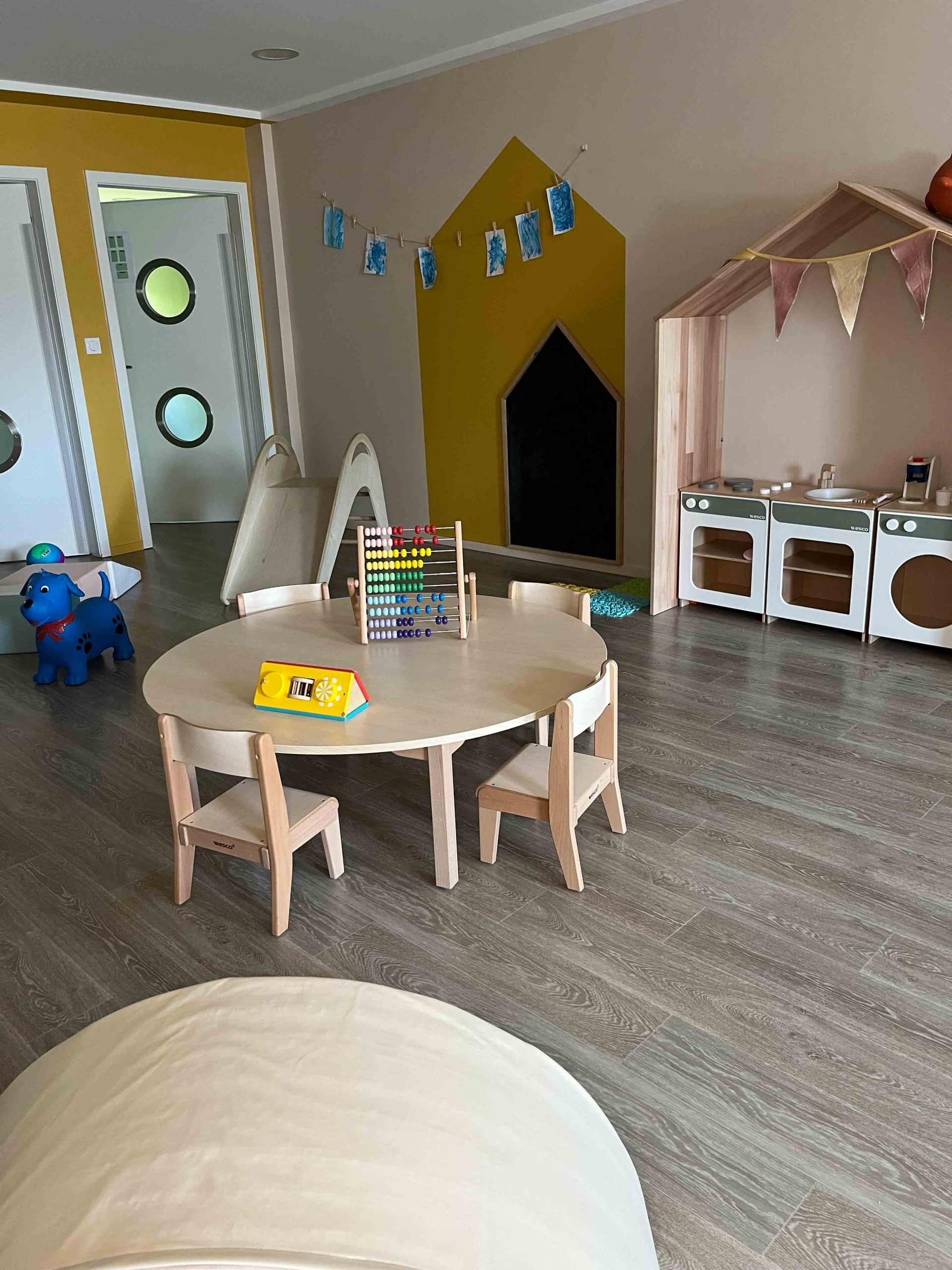 Espace de jeux avec mini cuisine, et table de jeux dans la micro crèche première escale de Colmar