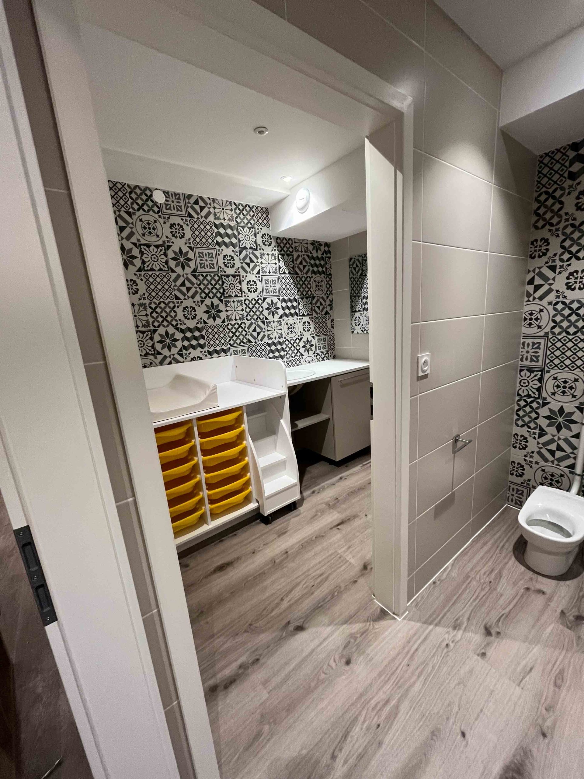 Salle de bain, avec carrelage décoratif, espace pour changer les enfants dans la micro crèche première escale à Colmar